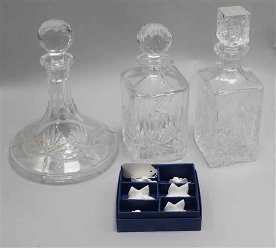 A cut glass ships decanter, two other decanters and stoppers and a set of Coalport menu holders (boxed)